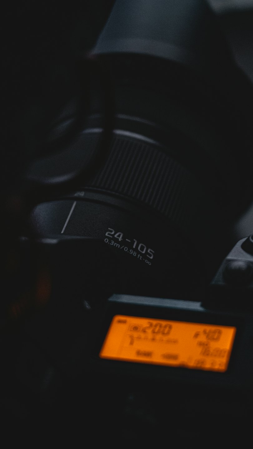 Un obiettivo di una fotocamera e un display digitale che mostra le impostazioni del dispositivo.
